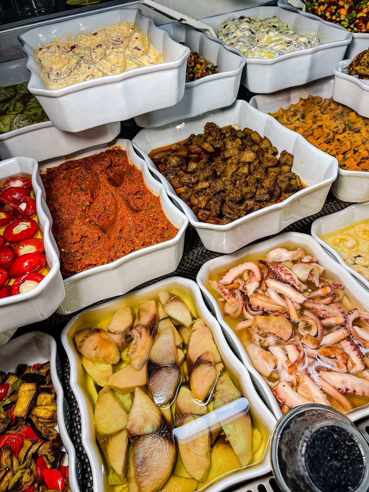 Schalen met bereide Griekse gerechten in een delicatessenwinkel